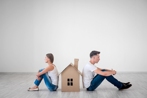 Quarreled couple with cardboard house